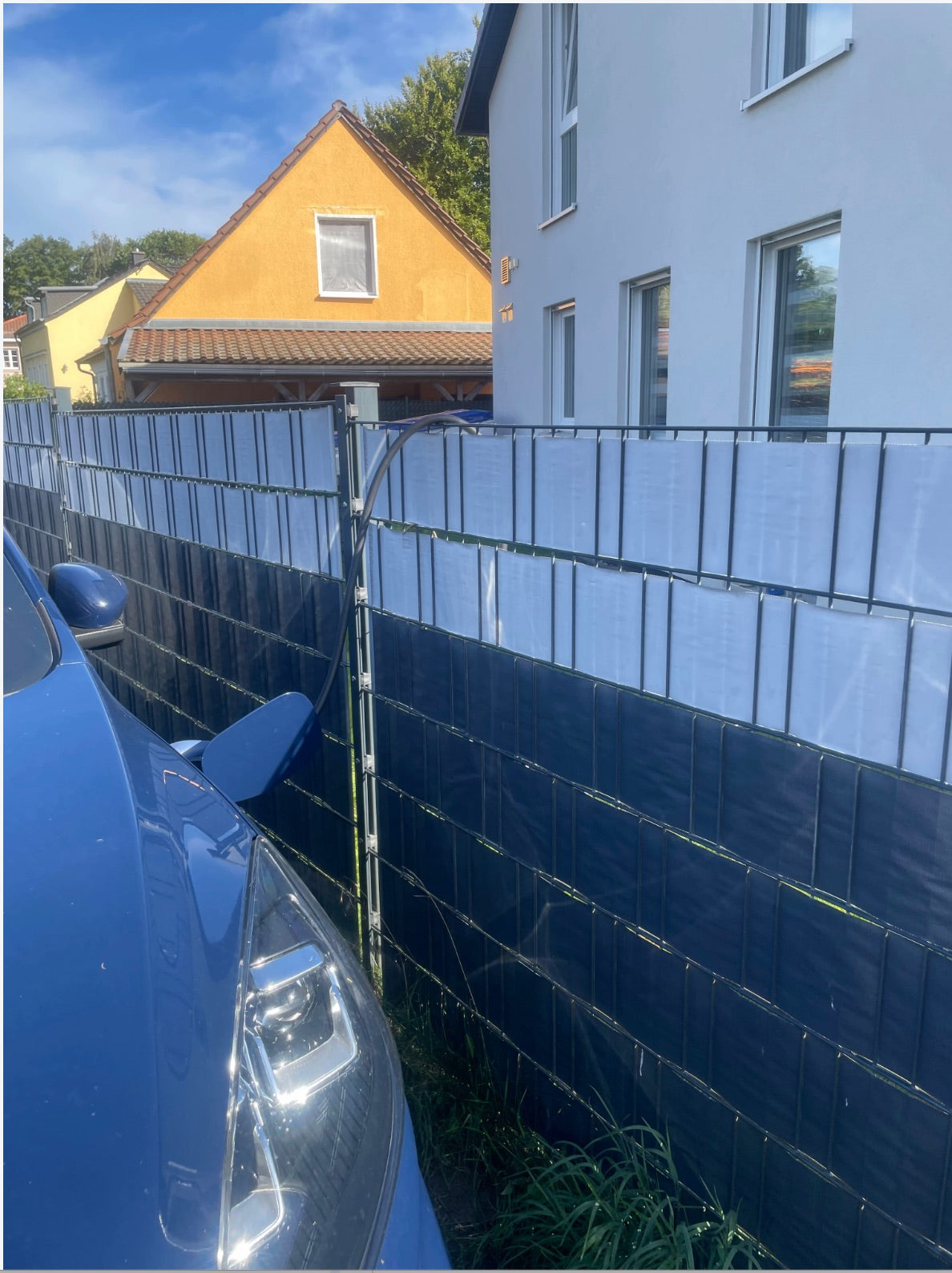 Marcels Auto steht außerhalb des Grundstücks am Zaun